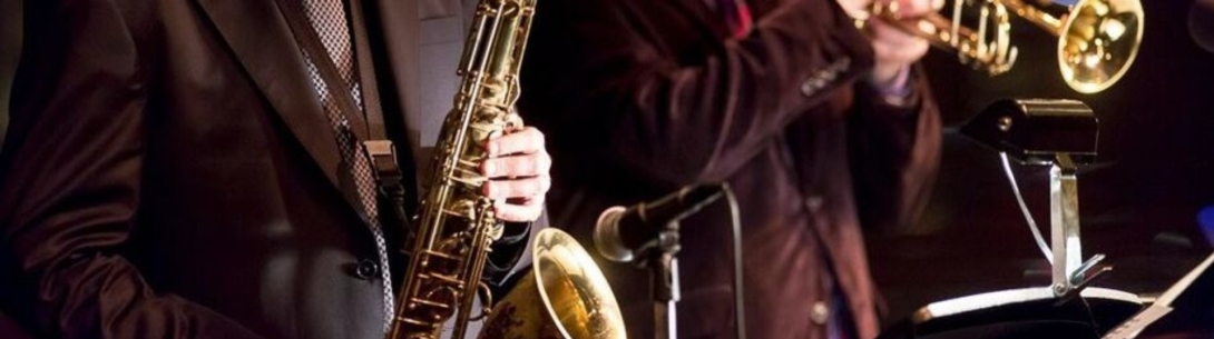 Musicians holding a saxophone and trumpet